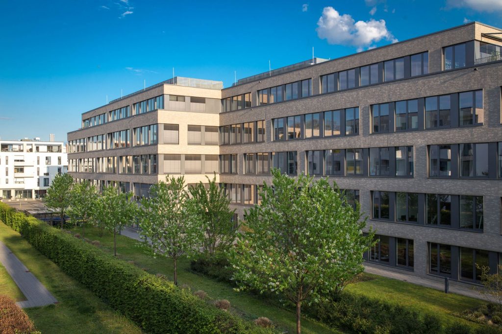 Mehrgeschossiger Bürokomplex von außen mit durchgehenden Fensterbändern und Klinkerfassade
